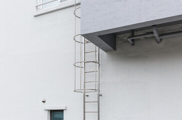 Steel ladder installed on a white building.