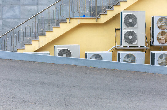 Stairs and ventilation fan in yellow building.