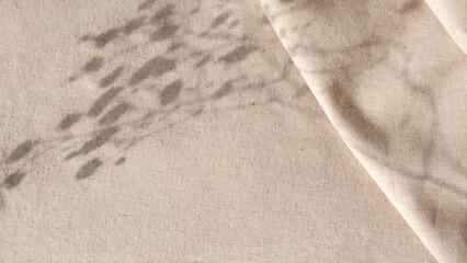 Aesthetic natural minimalistic background, elegant sunlight floral shadows on neutral beige linen texture pleated tablecloth, background with copy space - obrazy, fototapety, plakaty