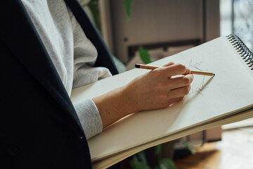 Cropped Image of Woman Drawing in Her Sketchbook