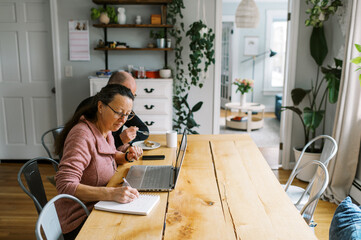 middle aged couple doing their finances together at kitchen table