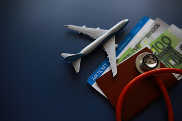 Passenger air insurance concept. Airplane, passport, boarding pass and stethoscope.