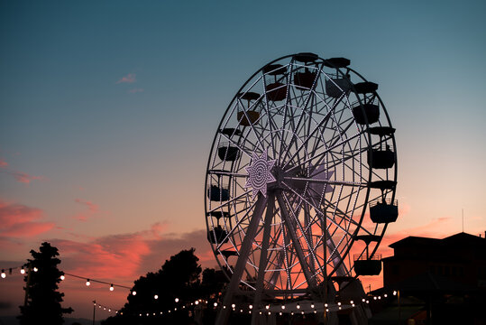Ferris wheel at theme park during sunset