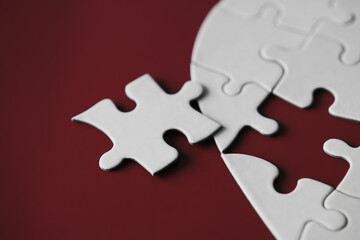 Clean puzzle elements on the red background. Empty puzzle piece on the table. Teamwork concept.