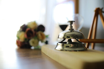 Hotel service bell on wooden reception desk. Space for text