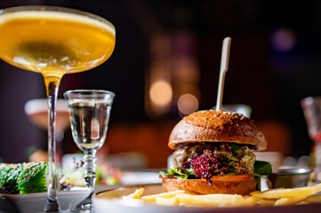 cheeseburger with chicken meat, vegetables and cheese on table