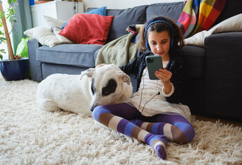 Kid at home with dog streaming on smartphone