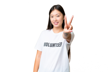 Young volunteer woman over isolated chroma key background smiling and showing victory sign