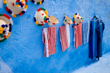 Hats and carpets on a blue wall
