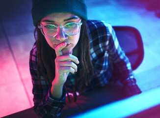 Cyber security, focus and woman hacker working on a computer in the basement at night for phishing. Database, password and ransomware with a female coder hacking a digital transformation network