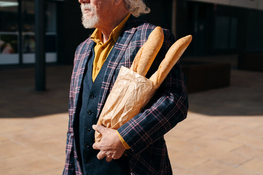 Man Holding A Bag With Baguettes