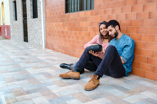 Couple enjoying music on a wireless speaker