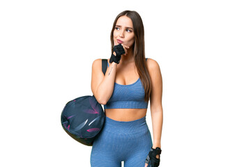 Young sport woman with sport bag over isolated chroma key background having doubts and with confuse face expression