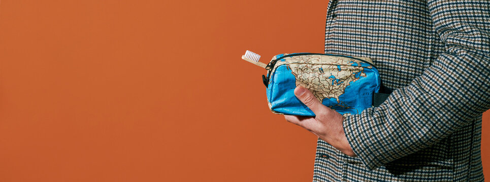 carries a map-patterned toilet bag, banner format