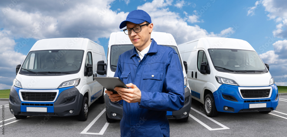 Poster Manager with a digital tablet on the background of vans. Fleet management	