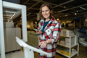 Woman uses the self-service kiosk in the store.