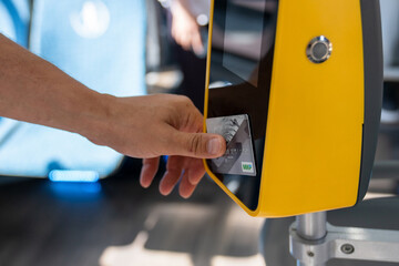 A man pays for travel by card in public transport. Moscow, Russia  - July 12, 2022 Payment for travel by bank card on the bus through the payment terminal. MIR payment card.