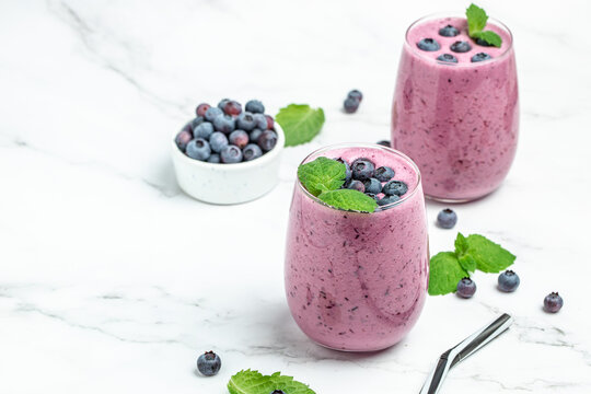 smoothie with fresh blueberries on a light background. Long banner format. top view