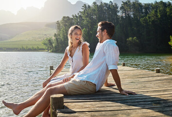 Love, laugh and pier with couple at lake for bonding, romance and affectionate date. Nature, travel...