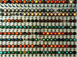 Old control panel with a large number of switches and bulbs in red, yellow and green