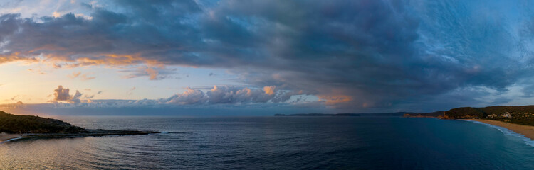 Rain cloud sunrise panorama over the sea