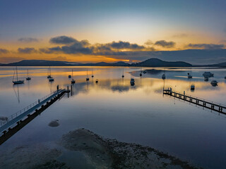 Soft and hazy aerial sunrise waterscape with boats