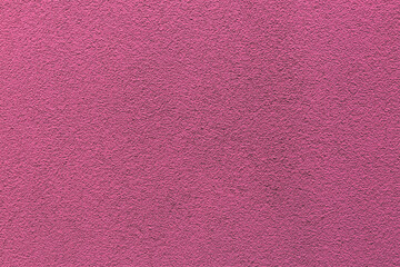 Sample of a texture of pink plaster. Wall finished with a decorative cement stucco. Example of exterior building decoration. Clean uniform grainy background. Banner. Wallpaper. Copy space. Pattern