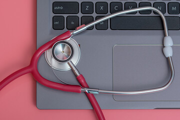 Czerwony stetoskop medyczny na laptopie - obrazy, fototapety, plakaty