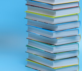 Stos książek ułożonych na sobie na niebieskim tle