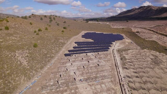 Aerial view of four engineers installing solar panels in a Solar Power Station under construction. Renewable Energy, Solar Energy, Spain
