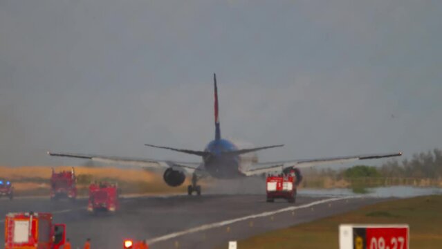 Airplane burning gear. Passenger plane on the runway, takeoff emergency stop, gear fire. Fire trucks follow the plane