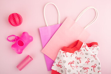 pet accessories, dog and cat tools and clothes with shopping bag on a pink background,top view, flat lay