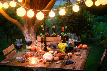 Rustic table with wine and appetizers in the summer evening