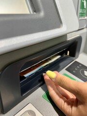 Close up of hands withdrawing money from the ATM. Unrecognizable people withdrawing money from an ATM. Electronic money withdrawal concept