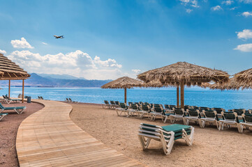 Morning on central public beach of the Red Sea in Eilat - famous tourist resort and recreational city in Israel. Concept of bliss vacation and happy holiday  