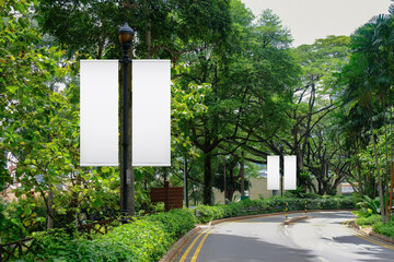 Blank vertical advertising banners on street lampposts; double hanging posters by the road, against...