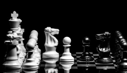 Close up of Chess pieces on a reflective mirror board surface wi