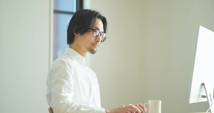 パソコンに向かってタイピングをする若い男性