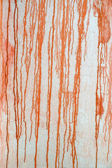 Texture of down flows of orange paint dripping down the wall. Creative background, abstract design element