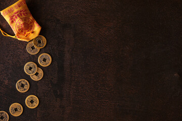 Arrangement of chinese lucky coins for good fortune and success, on dark rusty background with copy...