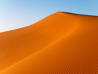 Fototapeta na wymiar Intricate wavy patterns seen on dunes near Merzouga, Morocco during sunset - Landscape shot