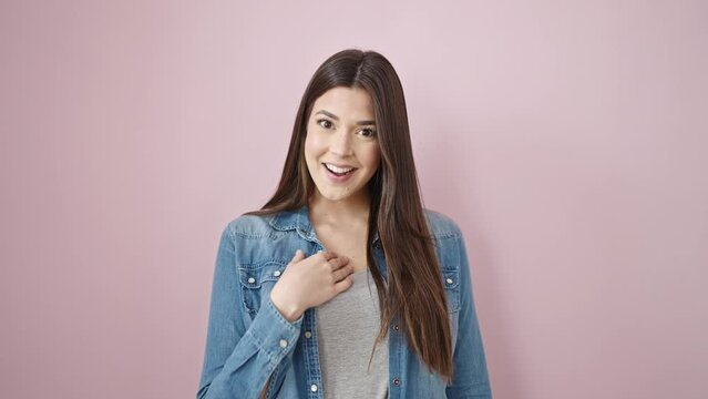 Young beautiful hispanic woman standing with cheerful expression over isolated pink background
