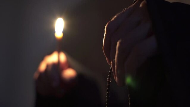 The monk is sorting out the rosary. Prayer in the temple