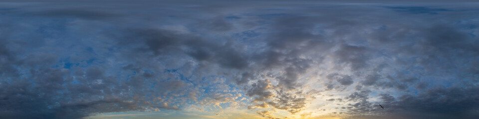Obraz premium Panorama of a dark blue sunset sky with golden Cumulus clouds. Seamless hdr 360 panorama in spherical equiangular format. Full zenith for 3D visualization, sky replacement for aerial drone panoramas.