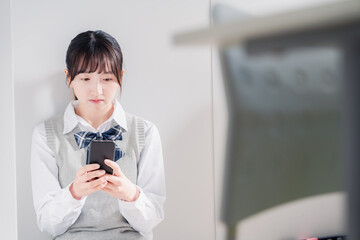 スマホを見ながら落ち込む女子高生