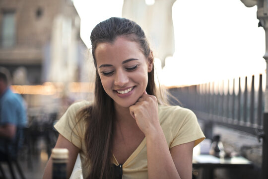 portrait of smiling young woman in outdoor restaurant