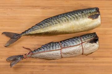 Hot and cold-smoked mackerels on cutting board, top view