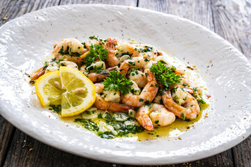 Fried prawns with thyme on wooden table