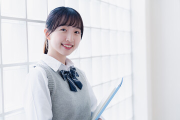 教材を持って校内を歩く女子高生