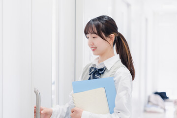 教材を持って校内を歩く女子高生